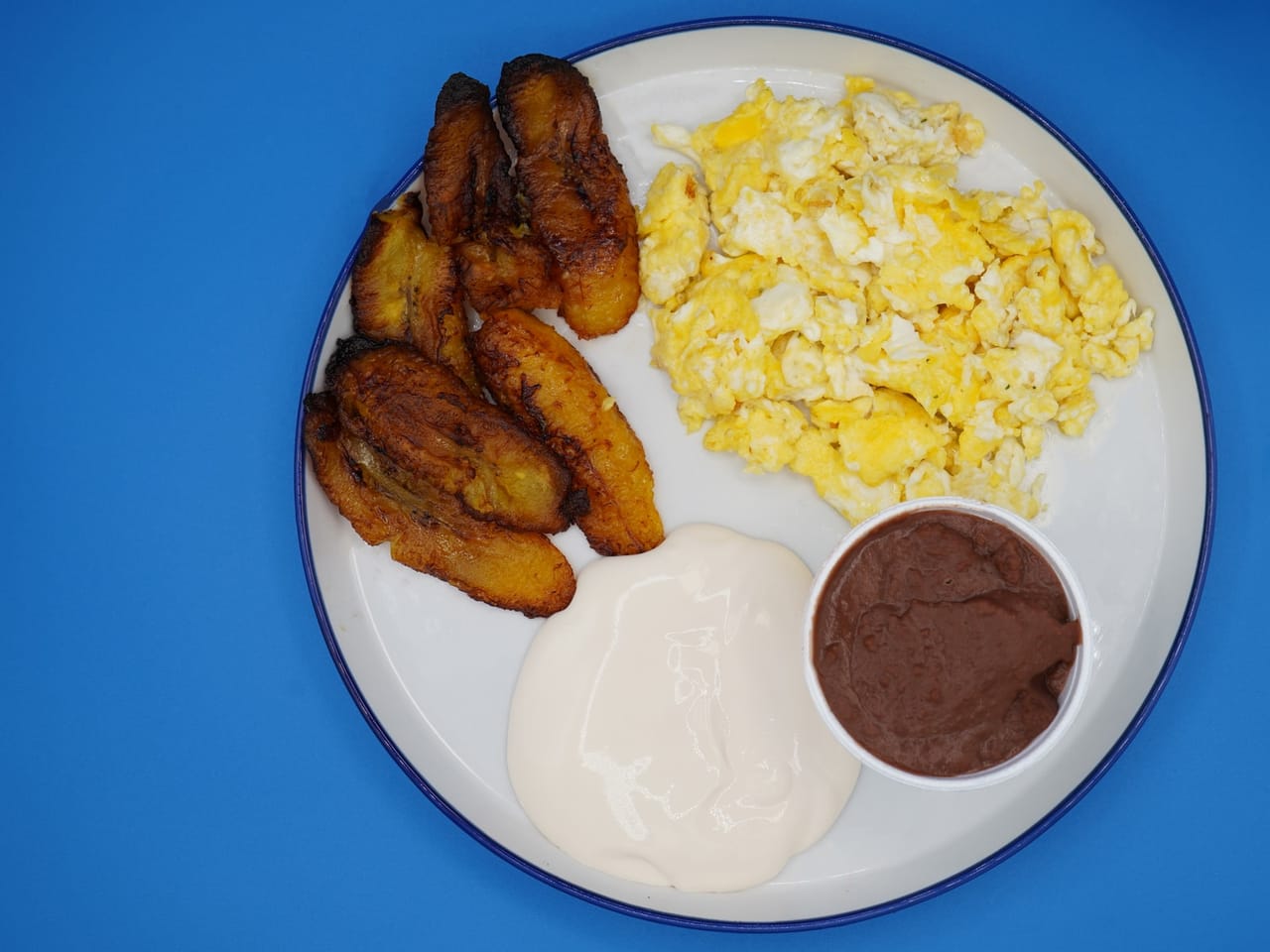 Desayuno típico salvadoreño con frijoles, huevos y plátano en Houston TX